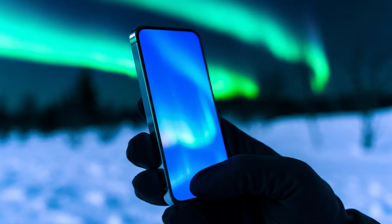 Smartphone med lysende skærm i Arktis